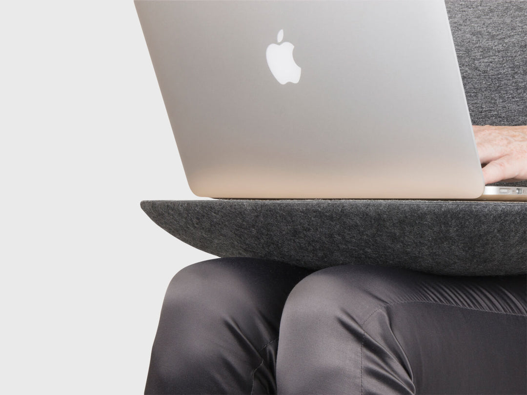 ObjctCo Lapod LapDesk comfortable cushion resting on lap with Macbook laptop above & person typing. Charcoal or Ash Grey felt