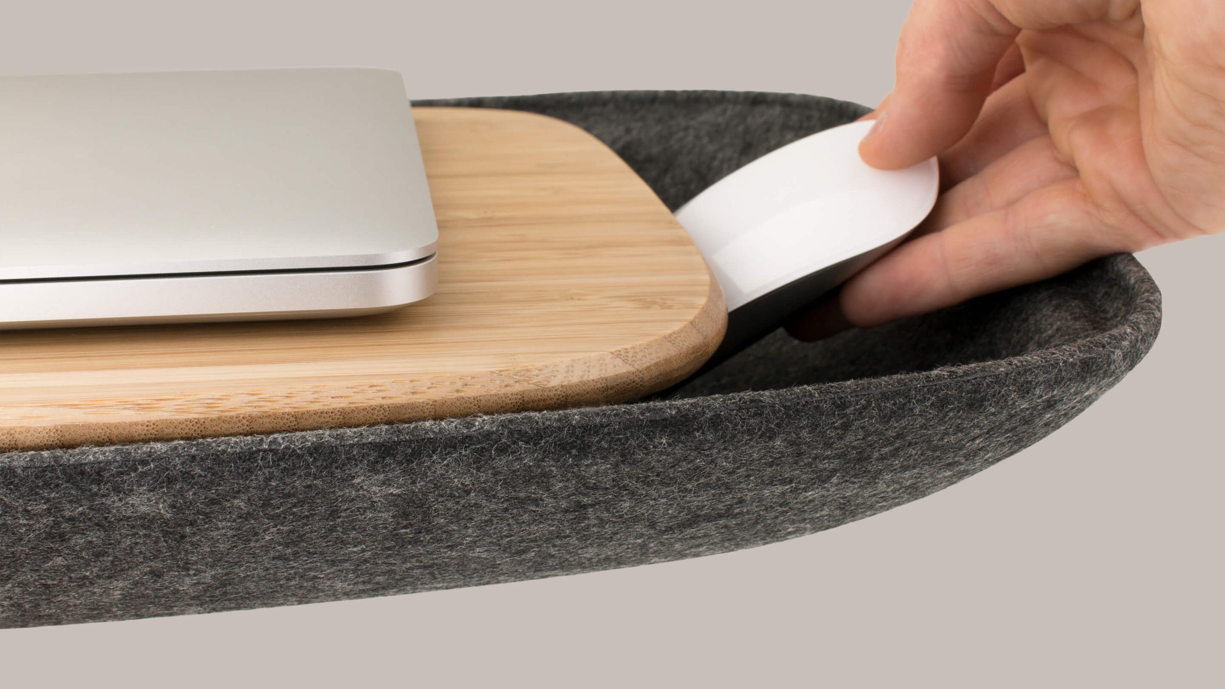 Detail holding laptop mouse in sustainable felt storage cushion of Charcoal or Ash Grey Objct Co portable Lapod Lap Desk