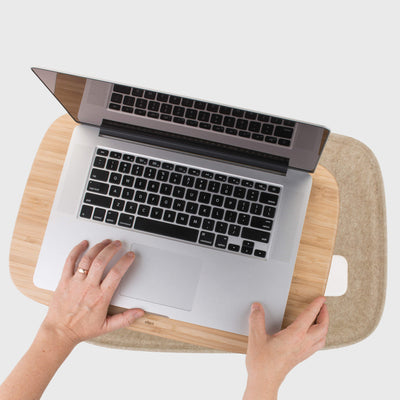Reaching in sustainable felt cushion organiser of Oatmeal or Ash Grey Lapod Lap Desk, by Objct Co, Mac laptop on tray