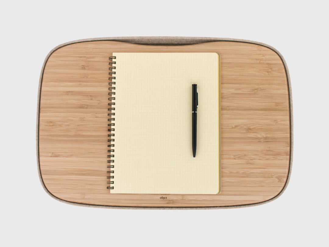Notepad & pen on Lapod Lap Desk by Objct, in Oatmeal or Ash Grey, bamboo tray and felt showing cable management slot